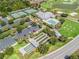 An aerial shot displays community amenities like a pool, tennis courts, and parking, set against a golf course backdrop at 3074 Eastwood Ter, The Villages, FL 32163