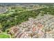 An aerial shot of a neighborhood bordering a golf course and wooded area showcases community living and scenic views at 3074 Eastwood Ter, The Villages, FL 32163
