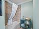 Bathroom featuring a bathtub and shower combination with a shower curtain, and a teal cabinet for storage at 3074 Eastwood Ter, The Villages, FL 32163