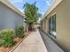 Exterior view of the home's side yard featuring a walkway and access to the screened lanai and windows at 3074 Eastwood Ter, The Villages, FL 32163