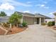 Charming single-story home featuring a well-kept front yard with beautiful landscaping and a two-car garage at 3074 Eastwood Ter, The Villages, FL 32163