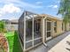 Exterior view of the screened-in lanai, adjacent to the house with neatly manicured lawn space at 3074 Eastwood Ter, The Villages, FL 32163