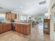 Open-concept kitchen with wood cabinets, modern appliances, and a breakfast bar overlooking the dining and living areas at 3074 Eastwood Ter, The Villages, FL 32163