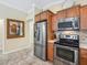 Modern kitchen featuring stainless steel appliances, wood cabinets, and a convenient layout for efficient cooking at 3074 Eastwood Ter, The Villages, FL 32163