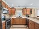 Well-equipped kitchen with stainless steel appliances, tiled backsplash, and wood cabinetry offering ample storage space at 3074 Eastwood Ter, The Villages, FL 32163