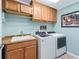 Well-equipped laundry room with modern washer and dryer, sink, ample cabinet space, and attractive tile flooring at 3074 Eastwood Ter, The Villages, FL 32163