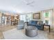 Open-concept living room with a view into kitchen and dining area, filled with lots of natural light at 3074 Eastwood Ter, The Villages, FL 32163