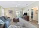 Cozy living area with tile floors, sliding doors to the patio, a leather ottoman, and a comfortable chair at 3074 Eastwood Ter, The Villages, FL 32163