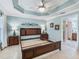 Primary bedroom features a trey ceiling, tiled floors, and neutral decor awaiting your personal touches at 3074 Eastwood Ter, The Villages, FL 32163