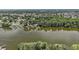 Aerial view of homes nestled among mature trees and a tranquil lake, offering a serene setting at 31941 Tropical Shores Dr, Tavares, FL 32778