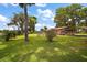 Spacious backyard showcasing lush greenery, mature trees, and the home's brick exterior at 31941 Tropical Shores Dr, Tavares, FL 32778