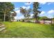 Lush backyard leading to a serene lake, adorned with mature trees and a cozy dock at 31941 Tropical Shores Dr, Tavares, FL 32778
