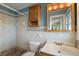 Bathroom with light blue walls, tile surround shower, toilet, sink, vanity, and cabinet at 31941 Tropical Shores Dr, Tavares, FL 32778