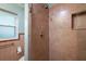 Bathroom with light green walls, tile surround shower with shelving, and fixtures at 31941 Tropical Shores Dr, Tavares, FL 32778