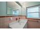 Bathroom with light green walls, white sink, vanity, mirror, and window for natural light at 31941 Tropical Shores Dr, Tavares, FL 32778