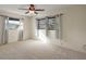 Bright bedroom with carpet, ceiling fan, curtains, and three windows bringing in natural light at 31941 Tropical Shores Dr, Tavares, FL 32778