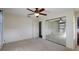 Bedroom with carpet, mirrored closet doors, and ceiling fan with light fixture at 31941 Tropical Shores Dr, Tavares, FL 32778