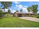 Charming single-story home with a well-manicured lawn, carport, and attached garage at 31941 Tropical Shores Dr, Tavares, FL 32778