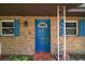 Close-up of a vibrant blue front door with decorative window and brick facade at 31941 Tropical Shores Dr, Tavares, FL 32778