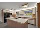 Kitchen features wood cabinets, an island cooktop, and plenty of natural light from multiple windows at 31941 Tropical Shores Dr, Tavares, FL 32778