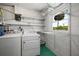 Laundry room showcasing washer, dryer, shelving, and a window offering natural light and outdoor views at 31941 Tropical Shores Dr, Tavares, FL 32778
