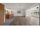 Open-concept living room with wood-look flooring flows into a kitchen area with an island and gray tile flooring at 31941 Tropical Shores Dr, Tavares, FL 32778