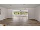 Bright living room with wood-look flooring showcases large windows providing plenty of natural light at 31941 Tropical Shores Dr, Tavares, FL 32778