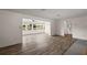 Open-concept living room with wood-look flooring connecting to the sunroom and hallway at 31941 Tropical Shores Dr, Tavares, FL 32778