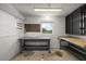 Functional workshop area with workbenches, pegboard, shelving, and natural light from a window at 31941 Tropical Shores Dr, Tavares, FL 32778