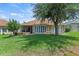 Back of house with screened in porch overlooking well-kept lawn and garden at 3257 Baltic Sea Blvd, Tavares, FL 32778