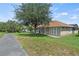 Back of house with walkway and view of enclosed patio and mature trees at 3257 Baltic Sea Blvd, Tavares, FL 32778