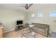 Bonus room with a sofa, ceiling fan, TV, and two windows at 3257 Baltic Sea Blvd, Tavares, FL 32778