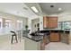 Kitchen with breakfast bar area, wood cabinetry, tile flooring and stainless steel dishwasher at 3257 Baltic Sea Blvd, Tavares, FL 32778
