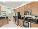 Open kitchen features stainless steel appliances, granite counters, and wood cabinets at 3257 Baltic Sea Blvd, Tavares, FL 32778