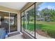 Screened porch overlooking a landscaped yard with a sliding glass door leading into the home at 3257 Baltic Sea Blvd, Tavares, FL 32778