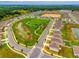 Aerial view of a Primary-planned community, showcasing a community park, pond, and neatly arranged homes at 33960 Sky Blossom Cir, Leesburg, FL 34788