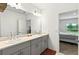 Stylish bathroom boasts a double vanity and an open view to the primary bedroom at 33960 Sky Blossom Cir, Leesburg, FL 34788