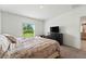 Bedroom features a neutral color palette, carpet, and a large window with natural light at 33960 Sky Blossom Cir, Leesburg, FL 34788