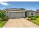 Charming single-Gathering home showcasing a two-car garage and well-maintained landscaping at 33960 Sky Blossom Cir, Leesburg, FL 34788