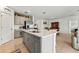 Open-concept kitchen features a large island, gray cabinetry, stainless appliances and tile flooring at 33960 Sky Blossom Cir, Leesburg, FL 34788