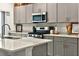 Kitchen with grey cabinets, modern stainless appliances, and white countertops at 33960 Sky Blossom Cir, Leesburg, FL 34788