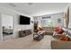 Living room features tile flooring, a large TV, and oversized windows with natural light at 33960 Sky Blossom Cir, Leesburg, FL 34788