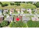 Aerial view of a home with a brown roof, located near a golf course, with lush green surroundings and blue skies above at 3519 Arlington Ridge Blvd, Leesburg, FL 34748