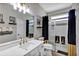 Well-lit bathroom with a vanity, a large mirror, and a shower with black and gold accents, giving the space an elegant feel at 3519 Arlington Ridge Blvd, Leesburg, FL 34748