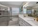 Bright bathroom with a glass enclosed shower, soaking tub, and double sink vanity with white cabinets and quartz counters at 3519 Arlington Ridge Blvd, Leesburg, FL 34748