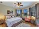 Stylish bedroom featuring a large bed, wood floors, a ceiling fan, and large windows providing lots of natural light at 3519 Arlington Ridge Blvd, Leesburg, FL 34748