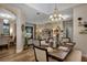 Open-concept dining room and living room featuring wood floors, stylish chandelier, and comfortable seating at 3519 Arlington Ridge Blvd, Leesburg, FL 34748