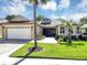 Charming home featuring a two-car garage, manicured lawn, and mature palm trees at 3519 Arlington Ridge Blvd, Leesburg, FL 34748