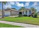 Well-maintained home featuring a two-car garage, manicured lawn, and mature palm trees at 3519 Arlington Ridge Blvd, Leesburg, FL 34748