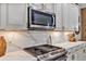 Updated kitchen features stainless steel appliances, modern white cabinets, and marbled quartz countertops at 3519 Arlington Ridge Blvd, Leesburg, FL 34748